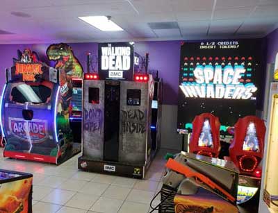 Arcade interior with Jurassic Park game, Walking Dead game, Space Invader